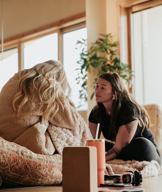Retreat facilitator providing emotional support during a guided healing exercise at a transformational women's retreat in Utah.